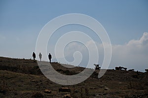 Family walks their dog on a ridge photo