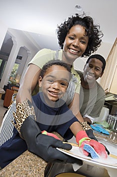 Family Washing Dishes At Kitchen Sink