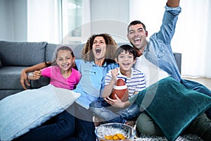 Family watching american football match on television