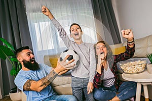 Family watching football match at home