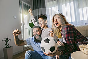 Family watching football match at home