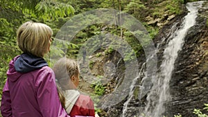 Family watching mountain waterfall