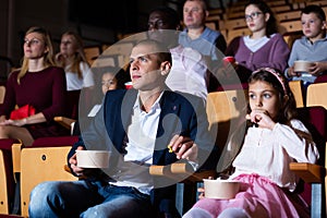 Family watching a movie in cinema hall