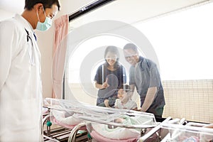 Family watching newborn in childbearing center and doctor