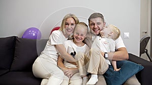 Family watching television. The family sits on the couch and watches TV.