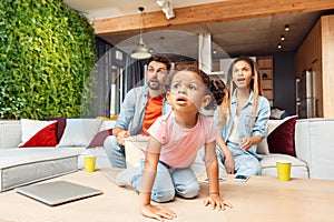 Family watching tv, making excited faces and resting at home