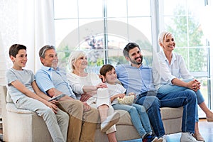 Family watching tv on sofa