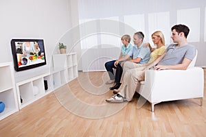 Family watching widescreen television