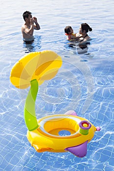 Family in water pool with children toy playing with happiness