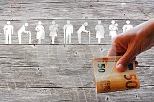 Family and Weak social categories welfare concept on wooden background with Euros in handr