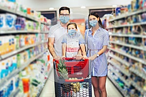 Family wearing face protective medical masks for protection from virus disease with shopping cart buying food at supermarket