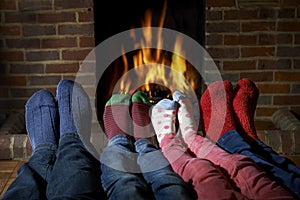 Family Wearing Socks Warming Feet By Fire