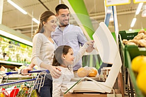 Family weighing oranges on scale at grocery store