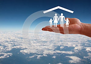 Family welfare concept with hand and roof on aerial sky view background