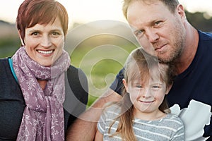 Family is where life begins and love never ends. Portrait of a cute little girl and her parents sitting outside together