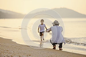 Family who enjoy a picnic. Father is carrying his son at the beach on sunset in holiday