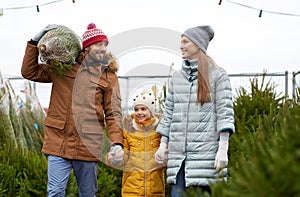 Happy family buying christmas tree at market