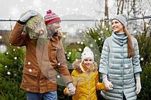 Happy family buying christmas tree at market