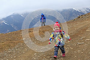 Family winter travel - little girl and boy hiking in mountains