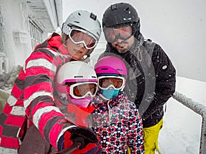 Family on winter vacations taking selfie on mountain slope