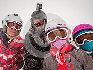 Family on winter vacations taking selfie on mountain slope