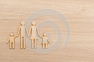 Family on a wooden background. Figures from natural wood. The concept of a loving family