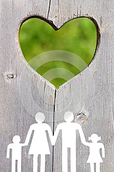Family on wooden background with green heart welfare concept