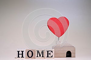 Family Wooden figure with a Wooden house With a Sign HOME  Letter Word on Orange Background
