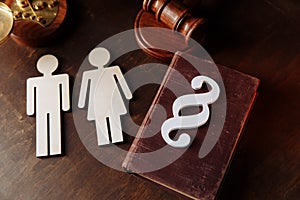 Family wooden figures, paragraph sign and law book. Divorce and separation concept