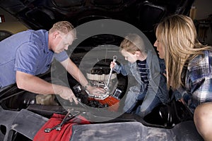 Family working on car