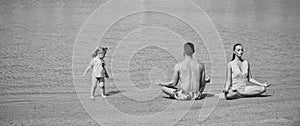 Family yoga. mother, father and child doing yoga exercises on beach