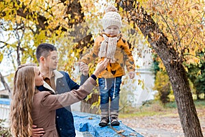A family with a young boy in the autumn forest walk