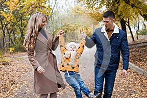 A family with a young son walk in the Park in autumn
