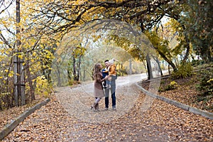 A family with a young son walk in the Park in autumn