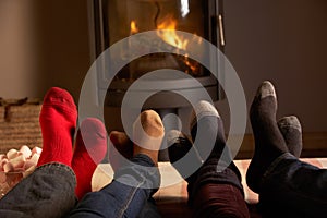 Familys Feet Relaxing By Cosy Log Fire