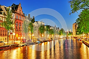 Famous Amstel river and night view of beautiful Amsterdam city.