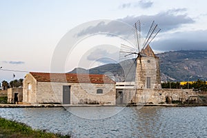 Famous ancient windmill of Riserva Naturale Saline Visitor Centre in Trapani, Sicily. It is producing sea salt using evaporation photo