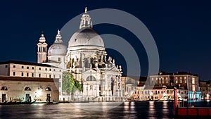 Famous Basilica di Santa Maria della Salute in Venice against a dark night sky