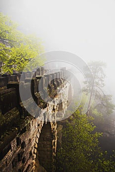 Famous Basteibruecke in Basteigebiet, Elbsandsteingebirge covered in fog in Saxony, Germany