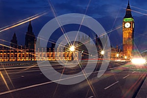 Famous and Beautiful night view to Big Ben and Houses of Parliament from Westminster Bridge through nigh lamp rays, London, UK