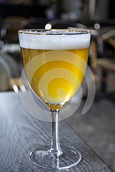 Famous Belgian beer served outside in small old cafe in special Belgian beer glass