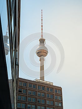 Famous Berlin Television Tower, observation Tower with office building in front, view from low angle during sunset, clear sky