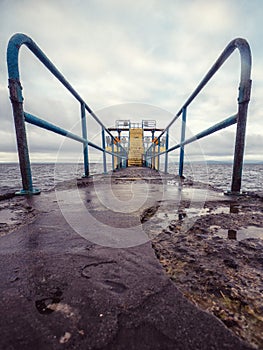 Famous Blackrock diving board in Salthill area of Galway city, Ireland. Cloudy sky over the ocean. Town landmark and tourist