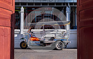 Famous blue Tuk Tuk, The front of thai traditional taxi with an old white wall behind
