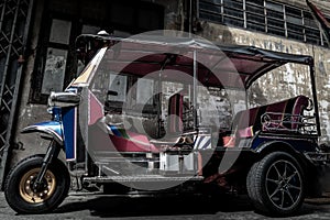 Famous blue Tuk Tuk, Thai traditional taxi with an old ancient wall behind