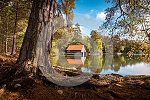 Famous boat house on this Strathspey Loch, on the shore of the water surrounded by trees