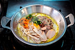 The famous breakfast thai food Panned eggs is fried egg topping with sausage, vegetable and bacon in the hot pan