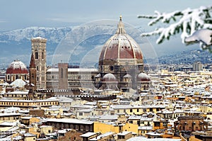 The famous Cathedral of Santa Maria del Fiore in Florence with the Dome covered with snow in december. View from Piazzale