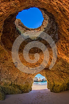 Famous caves in a beach rock formation in the Algarve, Portugal. Through the one cave you can see the ocean