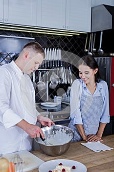 Famous chef disclosing a new recipe to a young cook photo